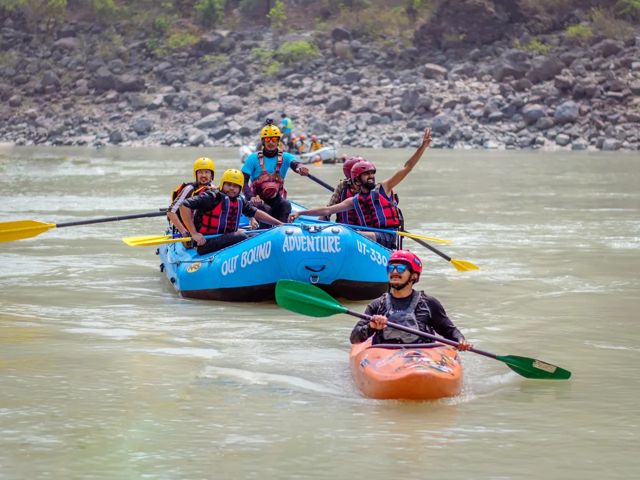 Rafting group travelling with a safety kayaker on a mountain river