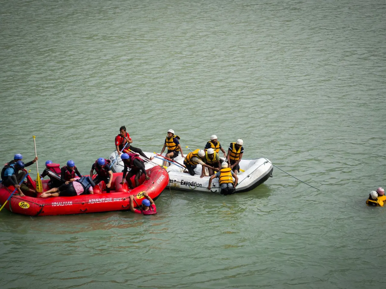 Two rafting teams gathered on calm green river water