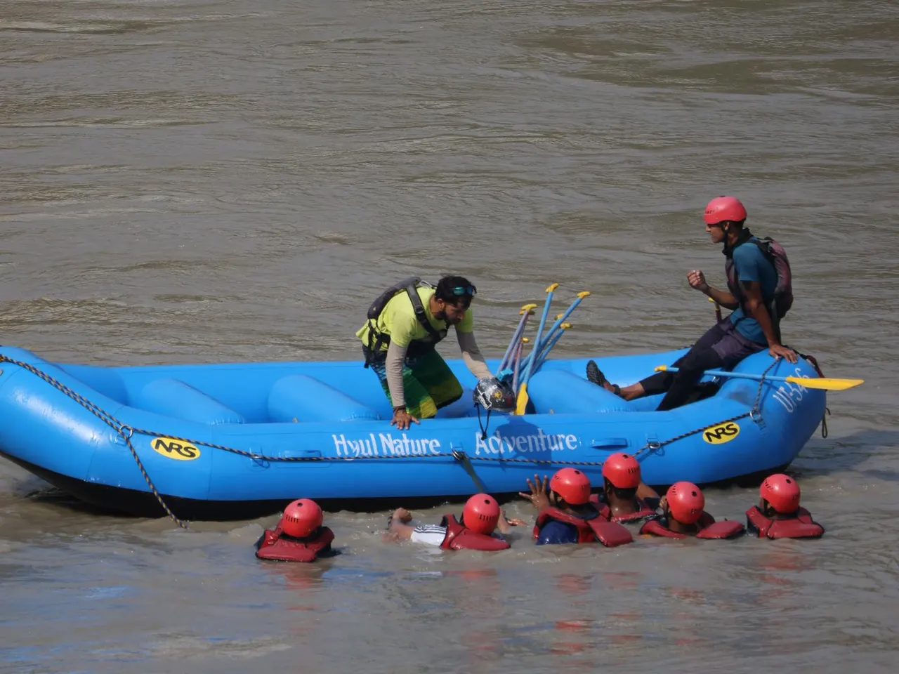 Participants holding the safety rope during a rafting rescue exercise