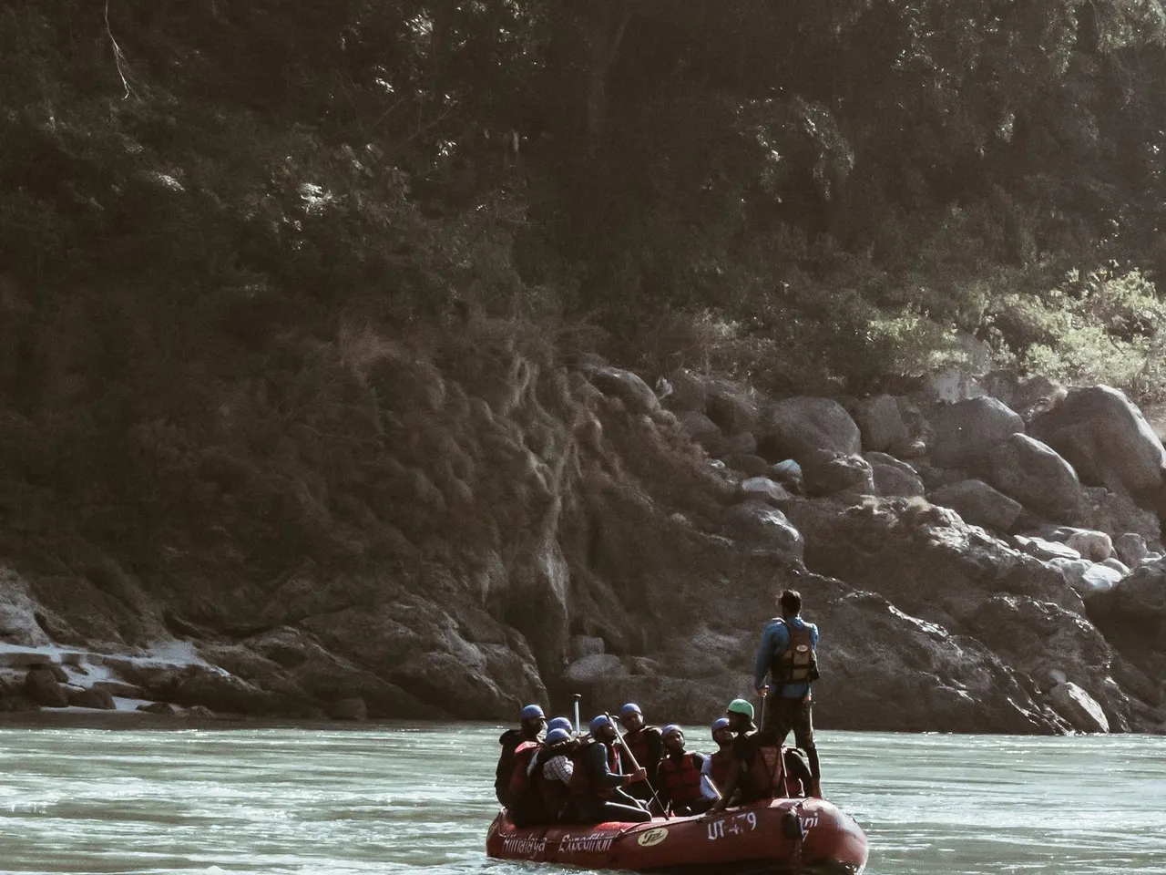 Rafting group paddling through a forested river gorge